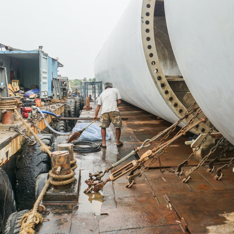 Bangkok / Thailand - December 27 2019: selective focus man work on board the barge with turbine project cargo while floating in Chaopraya River